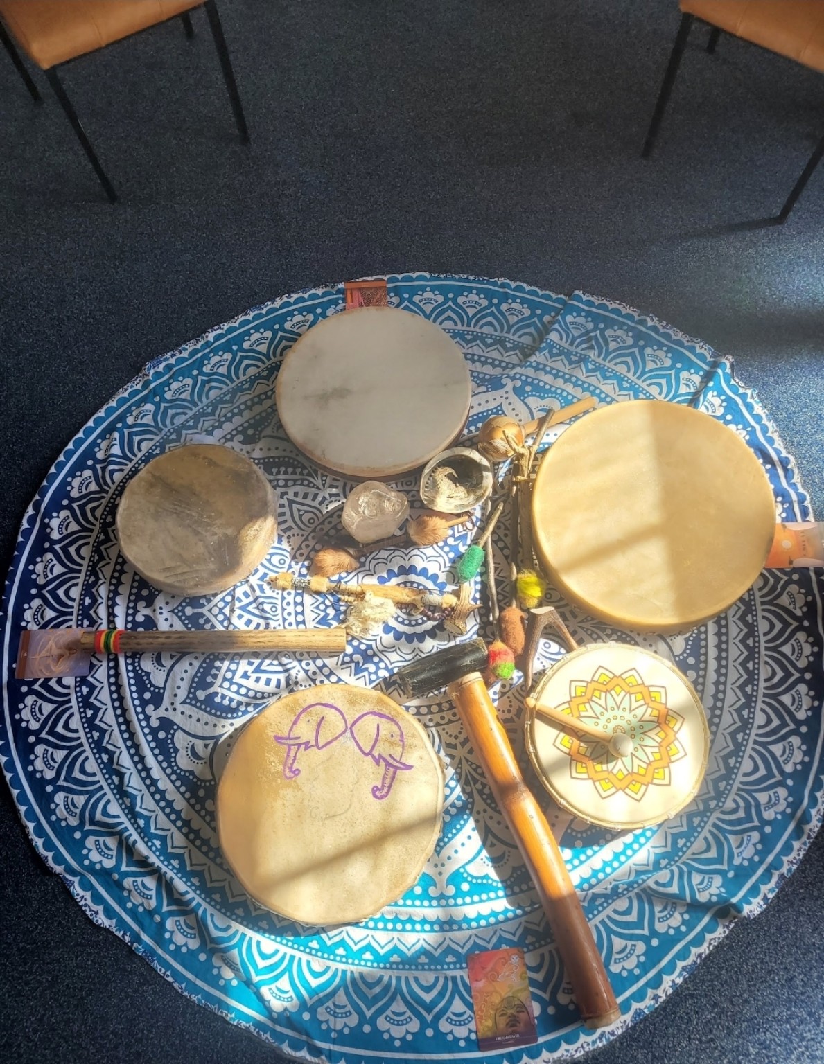 Handmade drums and beaters arranged on a patterned cloth
