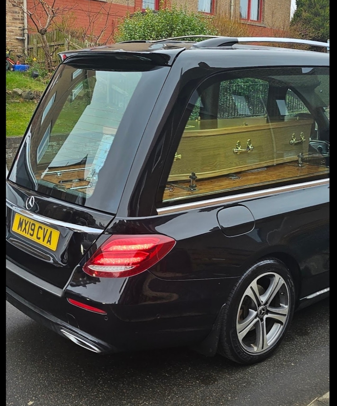 A hearse carrying a coffin on its final journey