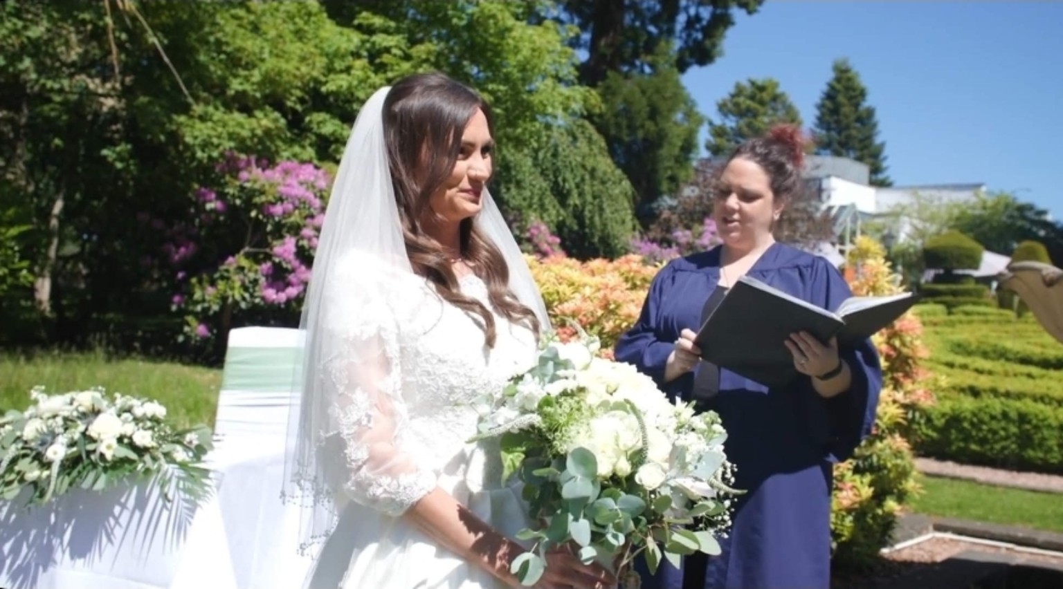 A celebrant leading an outdoor wedding ceremony
